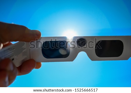 Sun viewed behind darkened solar eclipse glasses Royalty-Free Stock Photo #1525666517