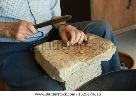 Man breaking almonds by hand
