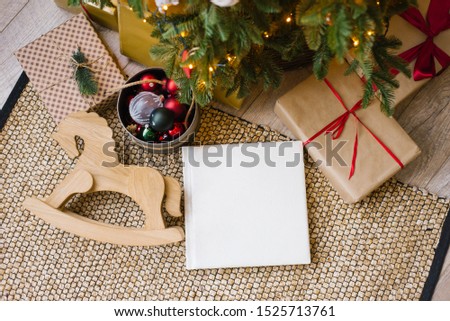 Photo book in white leather cover, wedding or family photo album under the Christmas tree surrounded by Christmas gifts Royalty-Free Stock Photo #1525713761