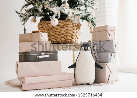 Christmas gifts and a soft toy penguin under the Christmas tree
