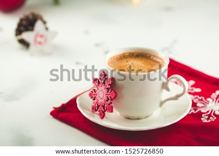 Cup of espresso or americano coffee in white cup in cosy Christmas arrangement, festive decoration with bokeh background, copy space