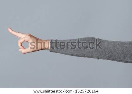 Okey gesture sign by female hand isolated on gray background.