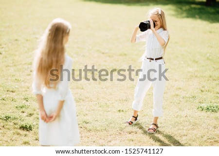 young girl takes camera outdoors , child with a camera