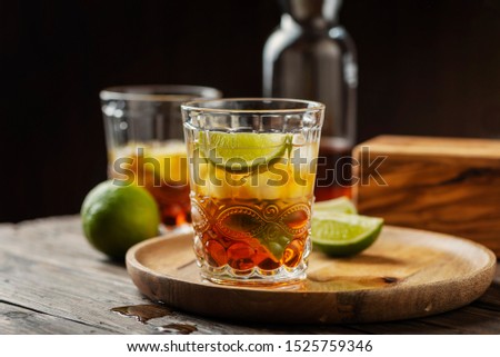 Strong golden rum with lime and ice, selective focus