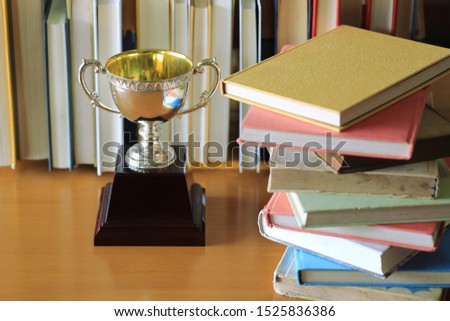 An ancient trophy on the table in the library Many books are lined up in the background selective focus and shallow depth of field