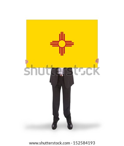 Smiling businessman holding a big card, flag of New Mexico, isolated on white