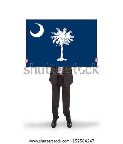 Smiling businessman holding a big card, flag of South Carolina, isolated on white
