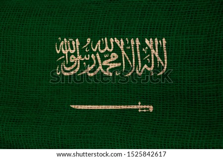 photo of the beautiful colored national flag of the modern state of Saudi Arabia on textured fabric, concept of tourism, economics and politics, closeup
