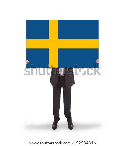 Smiling businessman holding a big card, flag of Sweden, isolated on white