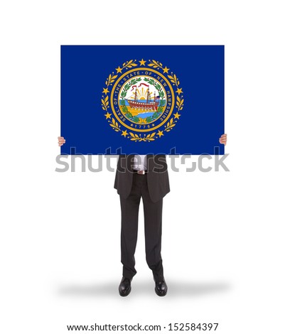 Smiling businessman holding a big card, flag of New Hampshire, isolated on white