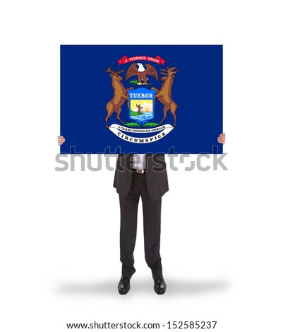 Smiling businessman holding a big card, flag of Michigan, isolated on white