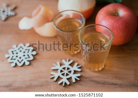 Hot mulled apple cider with with cinnamon sticks, snow flake and anise on wooden background.winter drink concept.