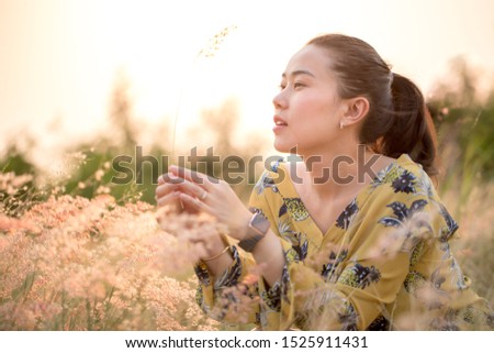 beautiful young  asian woman portrait at field and sunlight over her face, soft focus, blurry background
