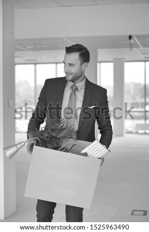 Black and white photo of  handsome businessman relocating to new office