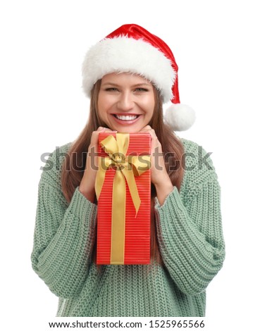 Happy young woman in Santa hat with Christmas gift on white background