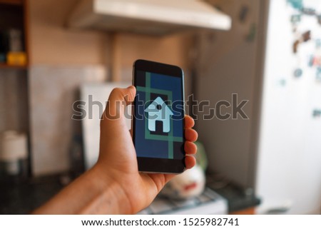 hand holding a smartphone with smart home application, modern technology