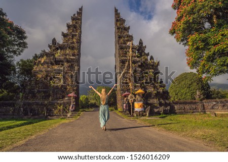 Tourist woman walking through Traditional Balinese Hindu gate Candi Bentar close to Bedugul,