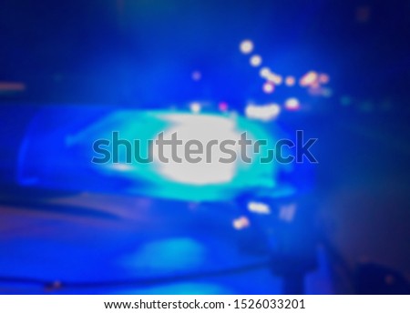 Abstract blurry image. Blue police car lights on the background of the night road, crime scene. Car accident concept.