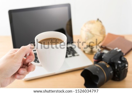 DSLR camera and laptop on wooden desk