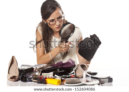 nervous girl searches inside of her bag by magnifying glass