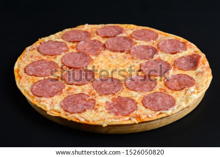 Whole hot Pizza pepperoni on black background