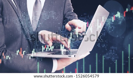 Businessmen using laptop with forex chart on blurry dark bokeh background. Teamwork and trade concept. Multiexposure
