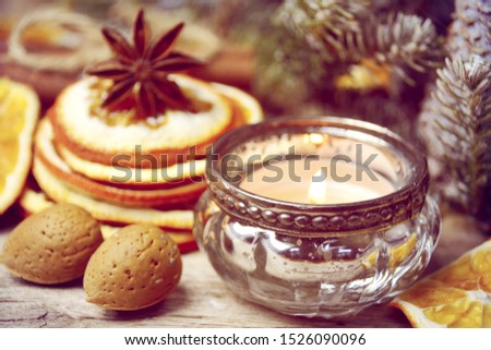 Natural christmas decoration with candle and orange slices on old wooden background
