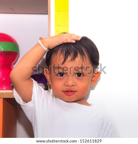 Little boy measuring his height  Royalty-Free Stock Photo #152611829