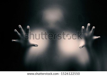 Creepy man holding the frosted glass with two hands. Creepy black and white version.  Creepy black and white version