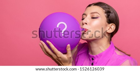 girl inflates a balloon.on the balloon is a question symbol. concept questions and answers.