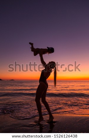 model and daughter at sunset by the sea 