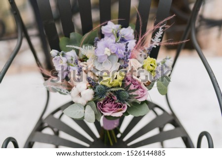 Beautiful modern bridal bouquet of colorful fresh flowers with sikl ribbons. Classic wedding traditional accessory.