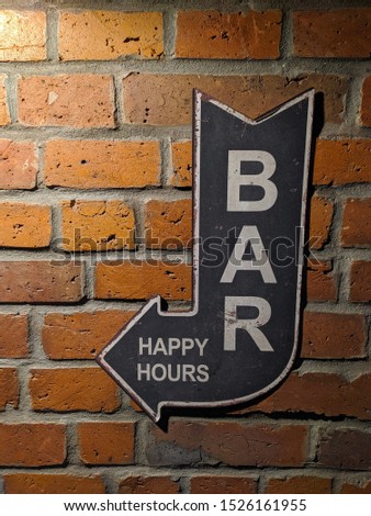 Bar sign, arrow shaped sign with bricks on background
