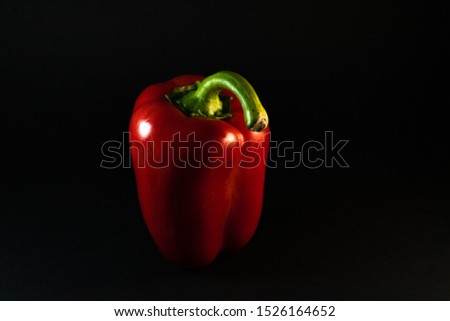 isolated and tasty red bell shiny paprika, pepper on the black clear background