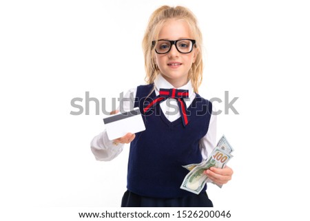 A little girl with blonde hair stuffed in a horse tail, large blue eyes and a cute face in square black glasses with a pass and dollars.