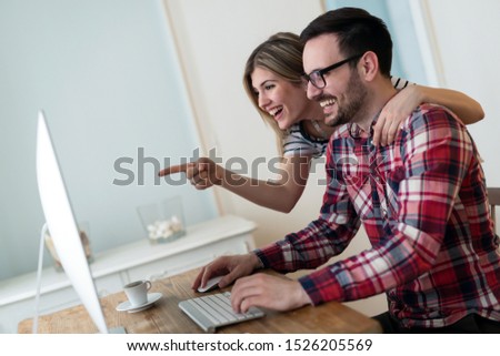 Young couple of designers working on computer