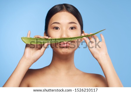 Aloe leaf beautiful girl sad face blue background Asian appearance