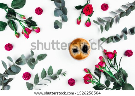 Isolated white background with a Cup of coffee surrounded by flowers. Flat lay, top view.