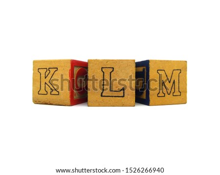 Closeup of wooden alphabet block toy on white background.