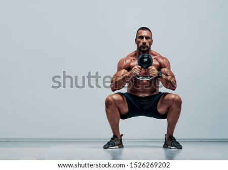Handsome Muscular , Training Athlete Doing Squats With Kettlebell Royalty-Free Stock Photo #1526269202