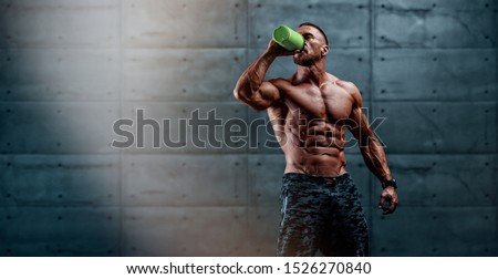 Nutritional Supplement. Muscular Men Drinks Protein, Energy Drink After Workout. copy space Royalty-Free Stock Photo #1526270840