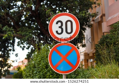 Road signs speed limit and no parking or stopping on green background