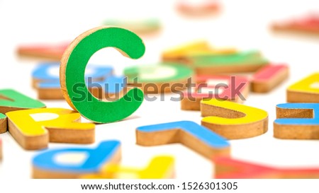 Close up education toys wooden scrabble Alphabet C letters macro photography isolated on white background