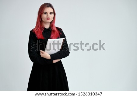 Portrait of a pretty student girl with colored hair in a black suit on a white background in studio.