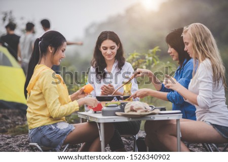 Camping concept - Group of happy friends doing outdoor activities. Party Young women  having fun and celebrate while  barbecue grilling.