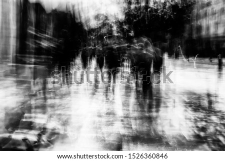 Long exposure of pedestrians walking along the high street - intentional camera shake to introduce an impressionistic effect and light trails - creative filter applied creating a ghostly aesthetic