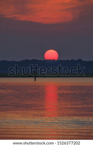 Sun setting over the river Royalty-Free Stock Photo #1526377202