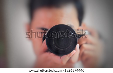 A man looks into the camera's viewfinder and takes a photo.