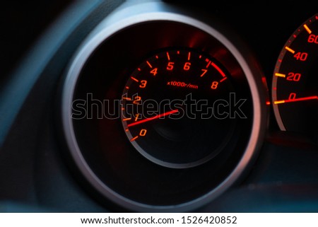 Close up of car speedometer with the needle pointing at  1 krpm on black blackground
