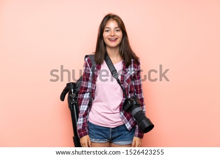 Young photographer girl over isolated pink background with surprise facial expression